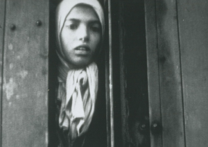 Still from the “Westerbork film” showing Settela peeking outside through the crack. Courtesy of the WWII Image Bank-   National Institute for War Documentation.